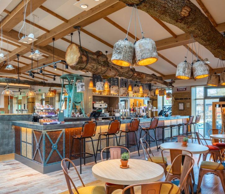 Ultra-modern bar and tables with feature tree trunks hanging from a beamed ceiling